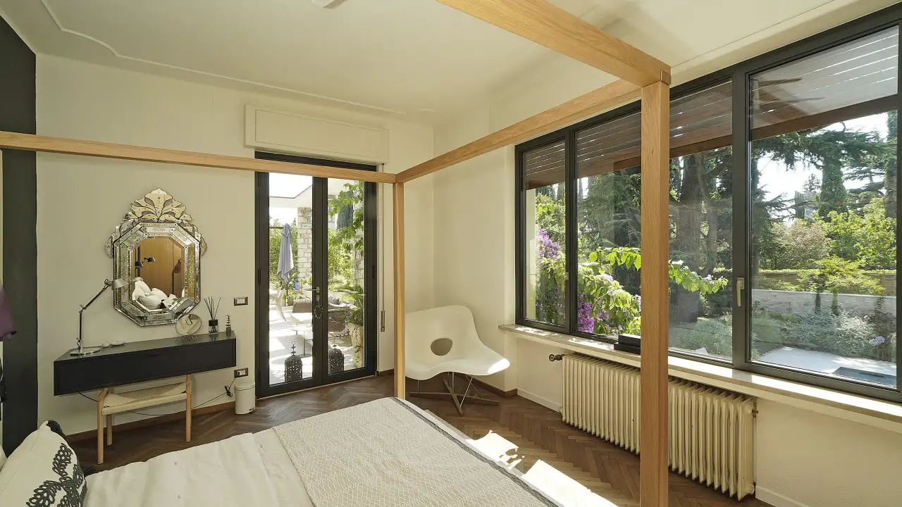 Schlafzimmer mit Himmelbett und Fenster mit Blick auf den Garten