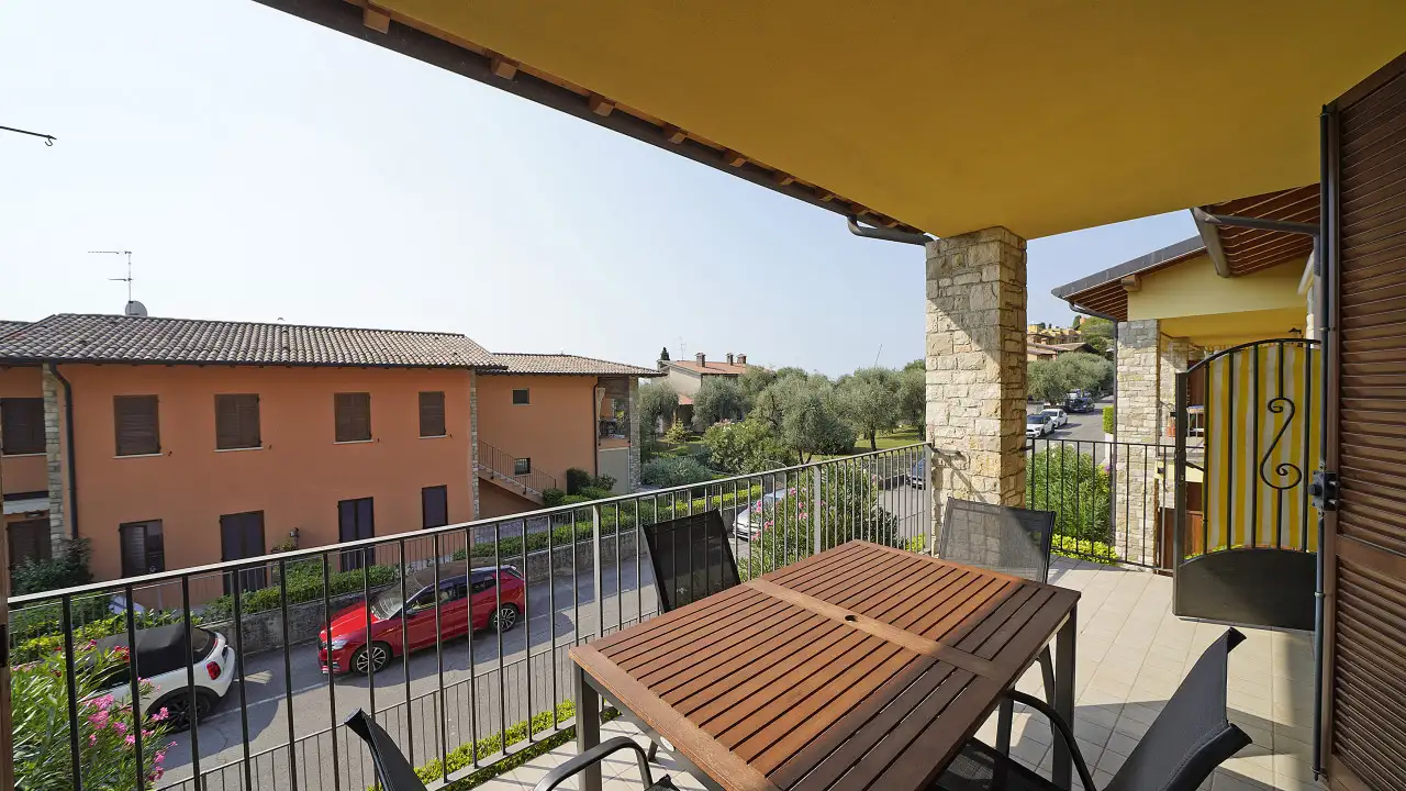 Terrazza con tavolo e sedie e vista sulla strada e case vicine