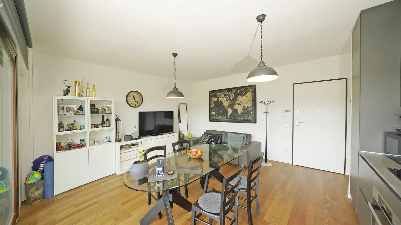 Wohnzimmer mit Glastisch und grauem Sofa