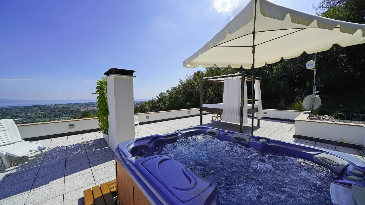 Terrazza con vasca idromassaggio e ombrellone bianco