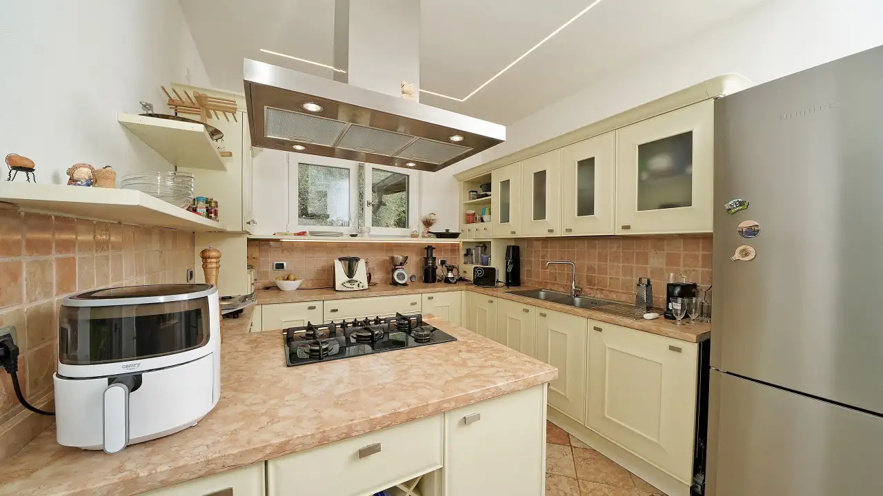 Kitchen with gas cooktop and stainless steel refrigerator