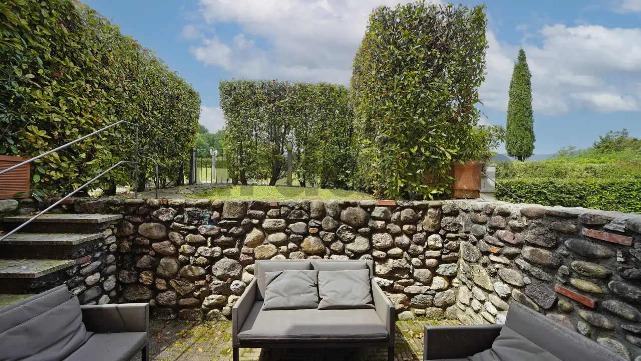 Garten mit Außensofas und hohen Hecken